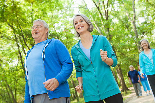 istock Healthy active senior couple jogging together in park 175192592