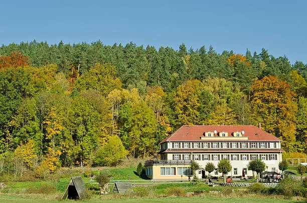Old framehouse in autumn. This house is an old mill in  Thuringia, Germany. A very known hiking area - Muhltal in the near of Eisenberg. Here shown the Amtsschreibermuhle - today a restaurant.