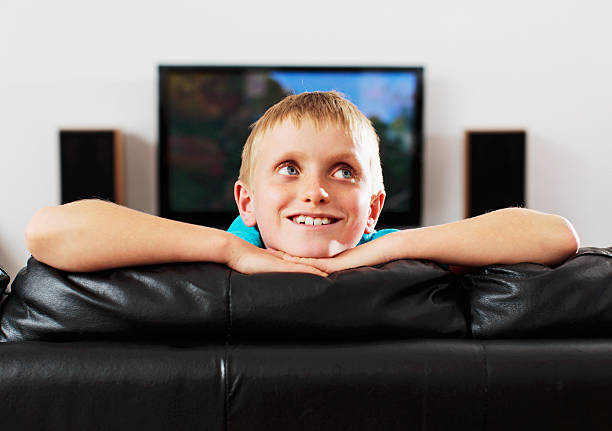 istock Little boy leans over back of couch looking up smiling 175194125