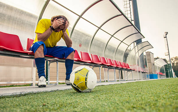 joueur de football, assis sur un banc - soccer guilt soccer player sitting photos et images de collection