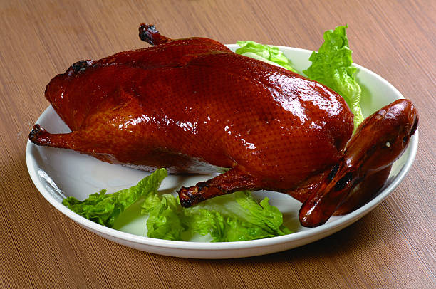 Peking duck served in white plate on white background.