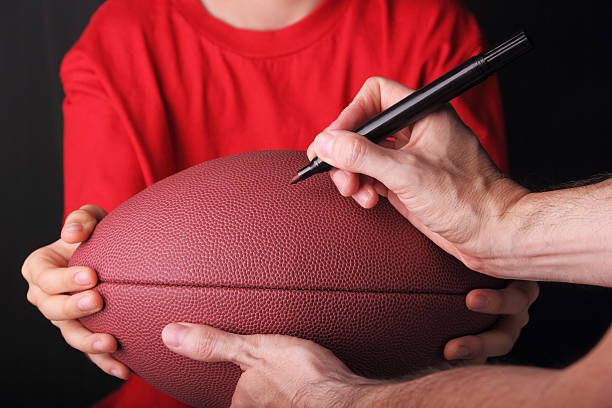 Boy getting his football signed by a football playerlSome other related images: