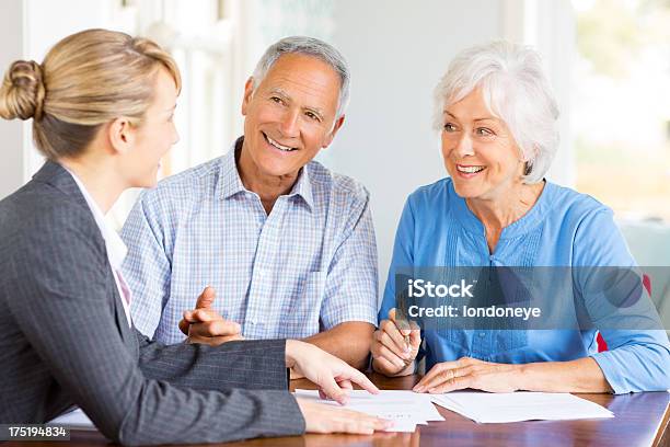 Foto de Feliz Casal Sênior Com Um Conselheiro Financeiro Em Casa e mais fotos de stock de Assinar