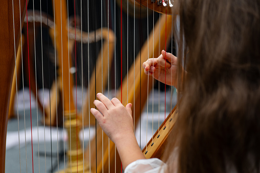 A little girl playing the harp