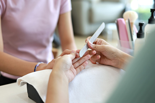 Close-up of beautiful female hands receiving a manicure treatment in a nail salon