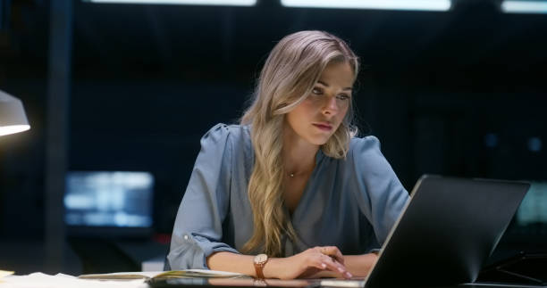 istock Code, typing and woman on laptop at night in office for information tech. Dark, engineer on computer and programming software at desk, business or serious web developer writing for startup deadline 1751963079