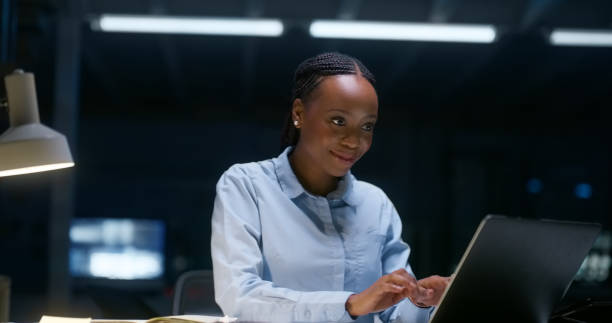 istock Happy black woman, laptop and night for project deadline, communication or networking at office. African female person or employee working late on computer in planning, strategy or ideas at workplace 1751963094