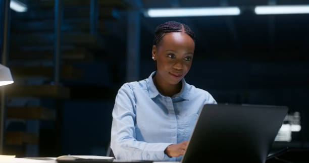 istock Programming, typing and black woman on laptop in office at night for information technology. Dark, engineer working on computer and coding software at desk or happy web developer planning on deadline 1751963097