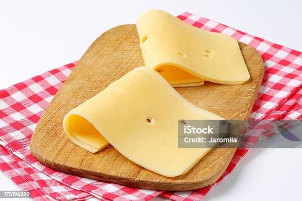 Two Slices Of Cheese On A Cutting Board Stock Photo - Download Image Now - Checked Pattern, Cheese, Close-up
