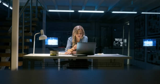 istock Programming, reading and woman on laptop at night in office for information technology. Dark, engineer on computer and code software at desk or serious web developer on deadline in business startup 1751964185