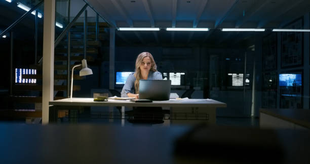istock Programming, typing and woman on laptop at night in office for information technology. Dark, engineer work on computer and code software at desk, business or serious web developer writing on deadline 1751964187