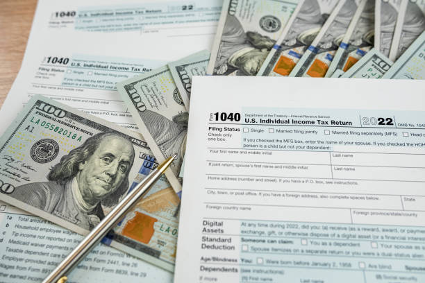 istock Tax payment with 1040 form pen and dollar bills 1751969779