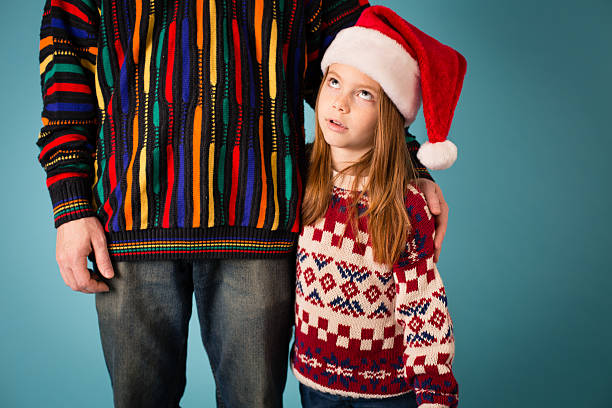 istock Little Girl Rolling Eyes at Dad, Both Wearing Ugly Sweaters 175197711