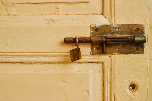 istock old metal lock latch on yellow dirty  door with padlock 1751978057