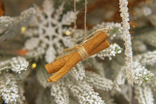 Christmas decoration on fir branches. Toy for Christmas-tree. Orange slice on the Xmas tree. Winter festive decor, flashing shiny lights. Many colorful balls, garland. Glittering illumination at night