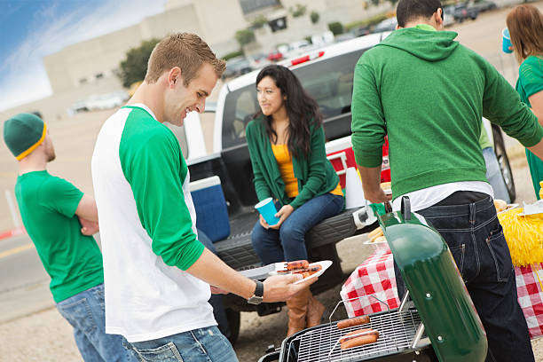 Fans having tailgate cook out at college football stadium Fans having tailgate cook out at college football stadium. tailgate party photos stock pictures, royalty-free photos & images
