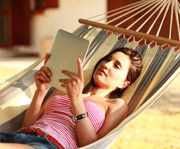 istock girl reading a tablet in hammock 175198362