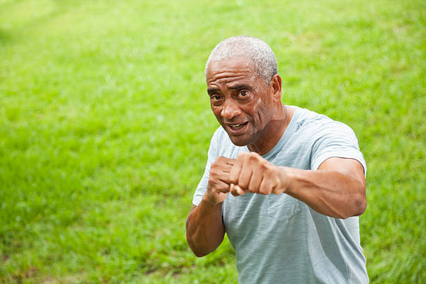 African American senior man outdoors African American senior man (60s) exercising outdoors. old man boxing stock pictures, royalty-free photos & images