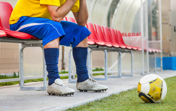 istock Soccer player sitting on a red bench with a soccer ball 175198475