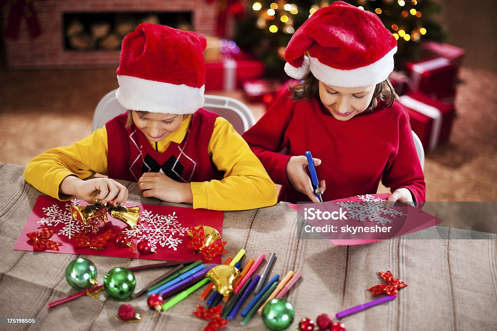 Beautiful kids making Christmas cards. Cute brother and sister making Christmas cards together. Christmas Card Stock Photo