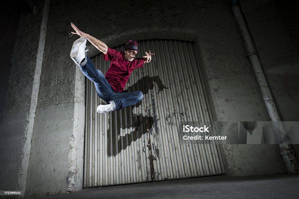 Модный человек, которые позируют в середине прыжки в воздухе на улице в ночное время. - Стоковые фото Ночь роялти-фри