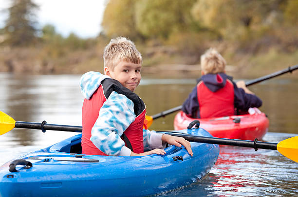 istock Young boy kayaking turning back to look at the camera 175199823