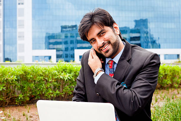 istock Young Asian Indian Businessman Using Laptop and Talking on Phone 175200538