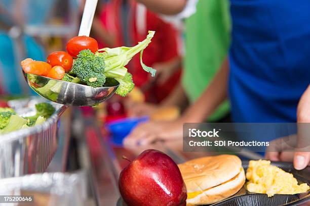 Photo libre de droit de École Étudiants Recevoir Des Légumes Dans La Ligne Du Déjeuner banque d'images et plus d'images libres de droit de Cantine scolaire