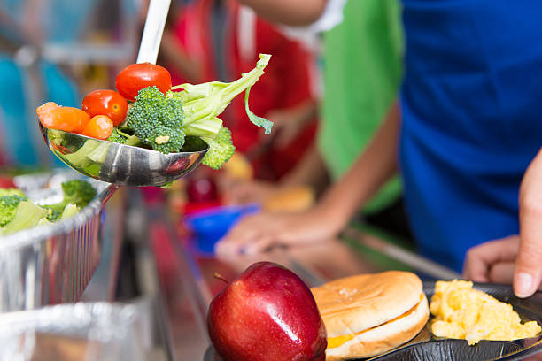 istock School students receiving healthy vegetables in the lunch line 175200646