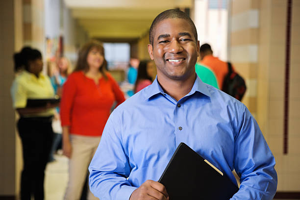 istock Happy high school teacher posing in hallway after class 175200647