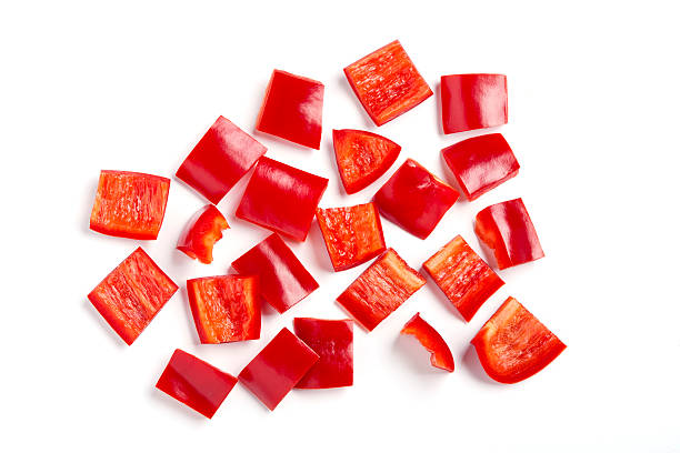 Pieces of diced red bell pepper against white background Chopped red pepper diced capsicum stock pictures, royalty-free photos & images