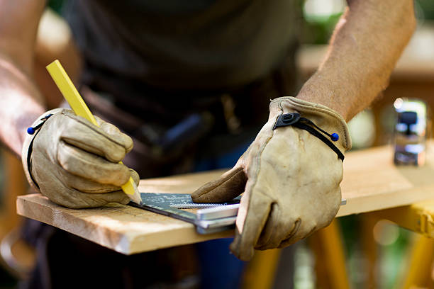 carpentiere di un asse di legno. - work glove immagine foto e immagini stock