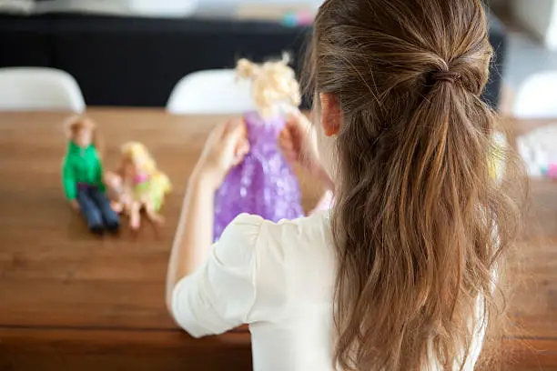 girl of 8 years old playing with dolls