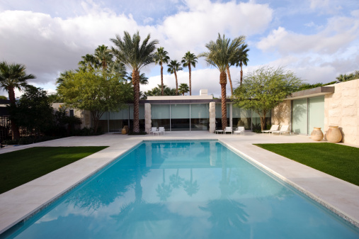 Wide angle image of a modern home with a rectangular shaped swimming pool.