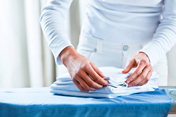 istock Woman Counting Stack of Ironed Folded Shirts 175203116