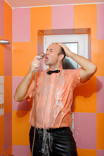 fun at shower young dressed man making shower and singing. shower men falling water soap sud stock pictures, royalty-free photos & images