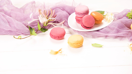 A french sweet delicacy, macaroons variety closeup. Color fresh macarrons on wooden background.