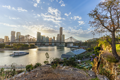 Sunset of Brisbane, Queensland showing the city skyline and Story Bridge, with cliffs, river and sunstar and entertainment bar and restaurant precinct Howard Smith Wharfs.