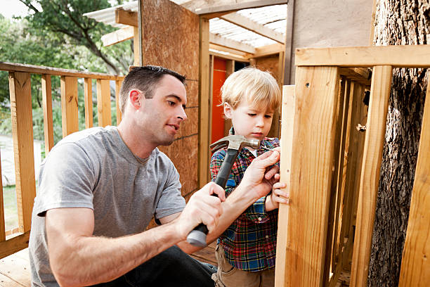 Father and Son Build Tree House A father and son build a tree house with hammer and nails.  Please see my portfolio for more images from this series. playhouse stock pictures, royalty-free photos & images