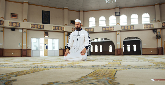 Man, islamic prayer and muslim in mosque for praise, respect faith or commitment to Allah. God, moslem culture and praying salah on carpet floor for spiritual worship, holy religion or trust in peace