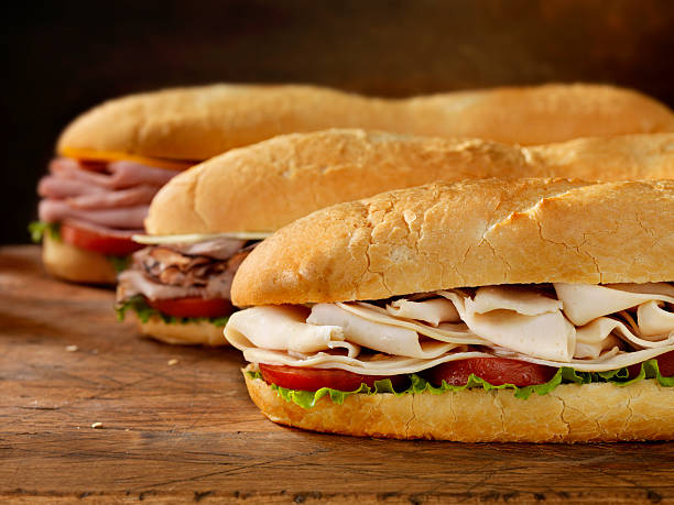 Three Foot Long Subs "Three 12 inch  Submarine Sandwiches- Turkey, Ham and Cheese, Roast Beef and Swiss with Lettuce and Tomato on Crusty Buns- Photographed on Hasselblad H3D2-39mb Camera" submarine sandwich photos stock pictures, royalty-free photos & images