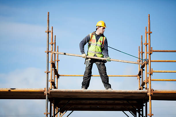 Construction worker setting up scaffolding against the sky Construction worker setting up scaffolding. scaffolding stock pictures, royalty-free photos & images