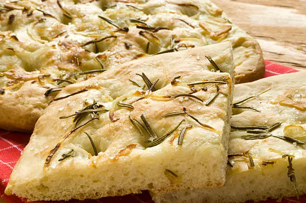 Slices of focaccia with rosemary, onions, garlic, olive oil and sea salt.