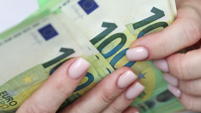 Young woman counting Euro bills in hands, closeup view.