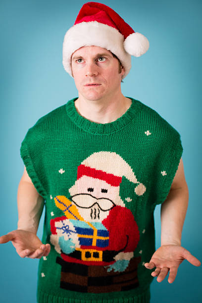 istock Man With Irritated Look Wearing Santa Hat and Ugly Sweater 175206132