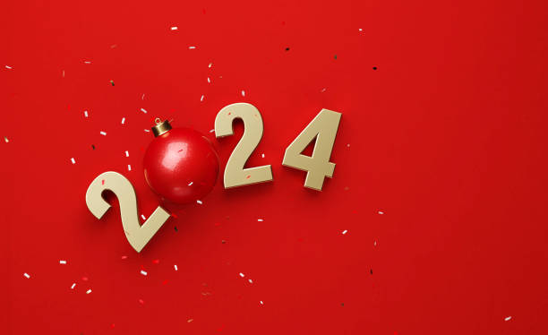 istock Christmas Concept - Confetti Falling Onto Red Bauble And Gold Colored 2024 Over Red Background 1752062174