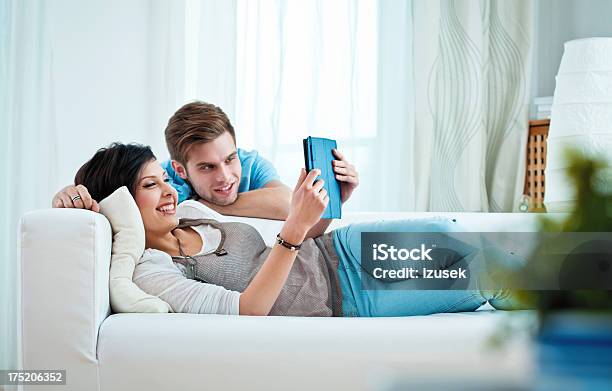Young Couple Using Ereader Stock Photo - Download Image Now - 20-24 Years, Adult, Adults Only