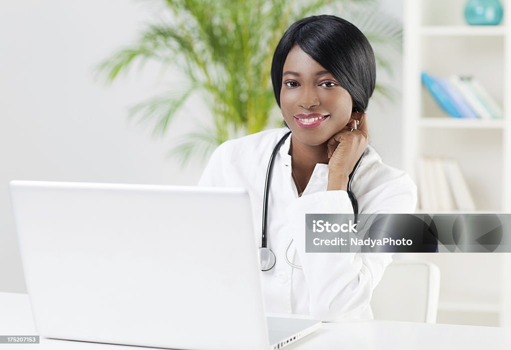 Female Doctor Female doctor sitting in her office. Lab Coat Stock Photo