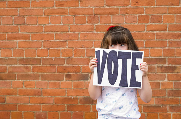 istock peeking over a sign to vote 175207203