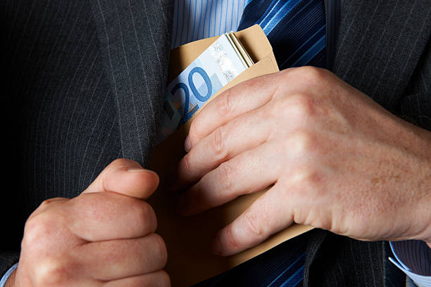 uomo d'affari mettendo busta di euro in tasca del giubbotto - corruzione foto e immagini stock